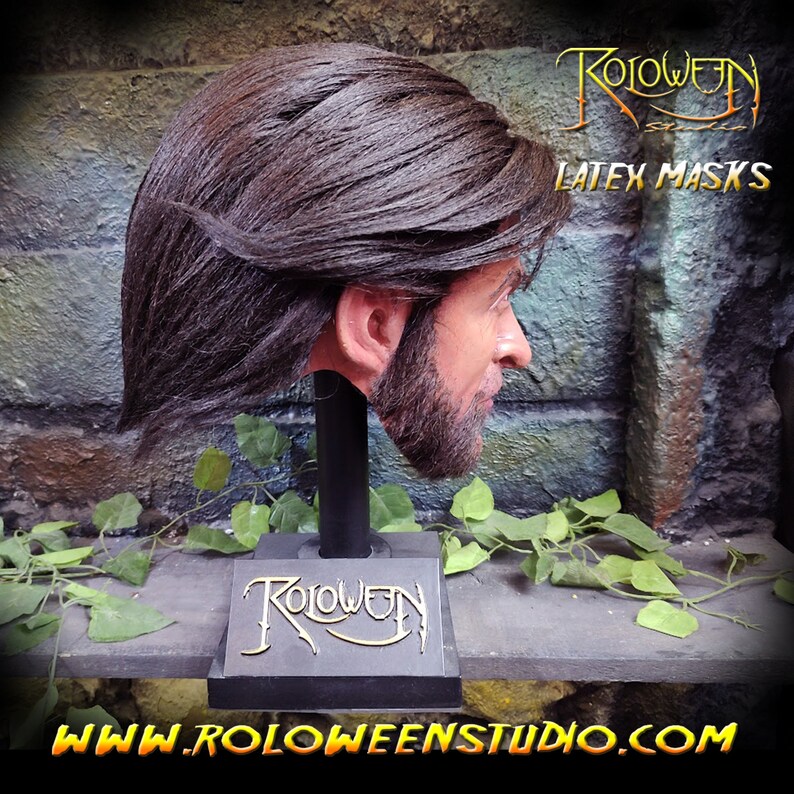 May include: A realistic latex mask of a man with long brown hair and a beard. The mask is mounted on a black stand with the word "Roloween" written on it. The text "Latex Masks" is also visible in the image.