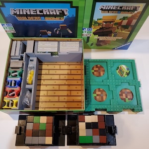 May include: A Minecraft Builders & Biomes board game box with a green lid and a gray insert. The box contains a variety of game components, including cards, tiles, and figures. The box is open and the game components are visible. The game is for 2-4 players and is recommended for ages 8 and up.