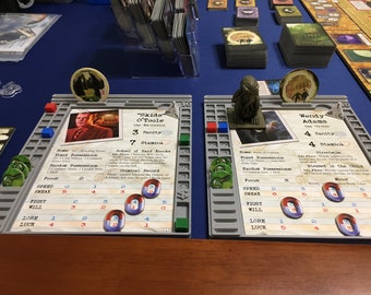 Pode incluir: Dois tabuleiros de jogo para o jogo de cartas Arkham Horror. Os tabuleiros são cinzentos com texto preto e fichas vermelhas e azuis. O texto nos tabuleiros inclui os nomes "Skids O'Toole" e "Wendy Adams".