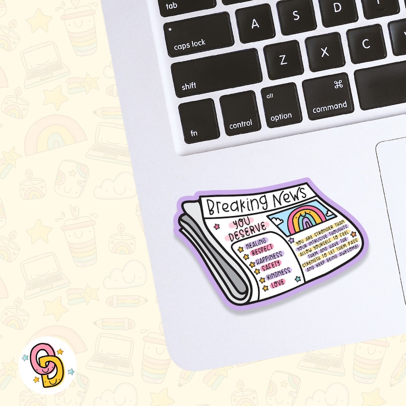 May include: A sticker of a newspaper headline that reads "Breaking News: You Deserve" with a list of positive affirmations including healing, respect, happiness, safety, kindness, and love. The sticker is on a laptop keyboard.