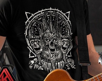 May include: Black t-shirt featuring a white graphic design of a skull with horns and the text "Skull Lord". The graphic is encircled by a circle of text. The person wearing the shirt is holding a guitar.