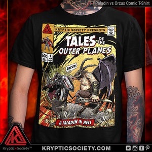 May include: A black t-shirt with a comic book style graphic of a paladin fighting a demon. The graphic is titled "Tales of the Outer Planes" and features the text "A Paladin in Hell" and "Orcus!"