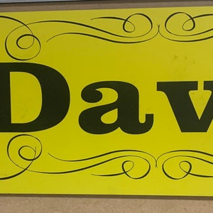 Peut inclure: Panneau jaune avec du texte noir et une illustration noir et blanc d'un semi-remorque. Le texte indique "Born to Truck" et "David".
