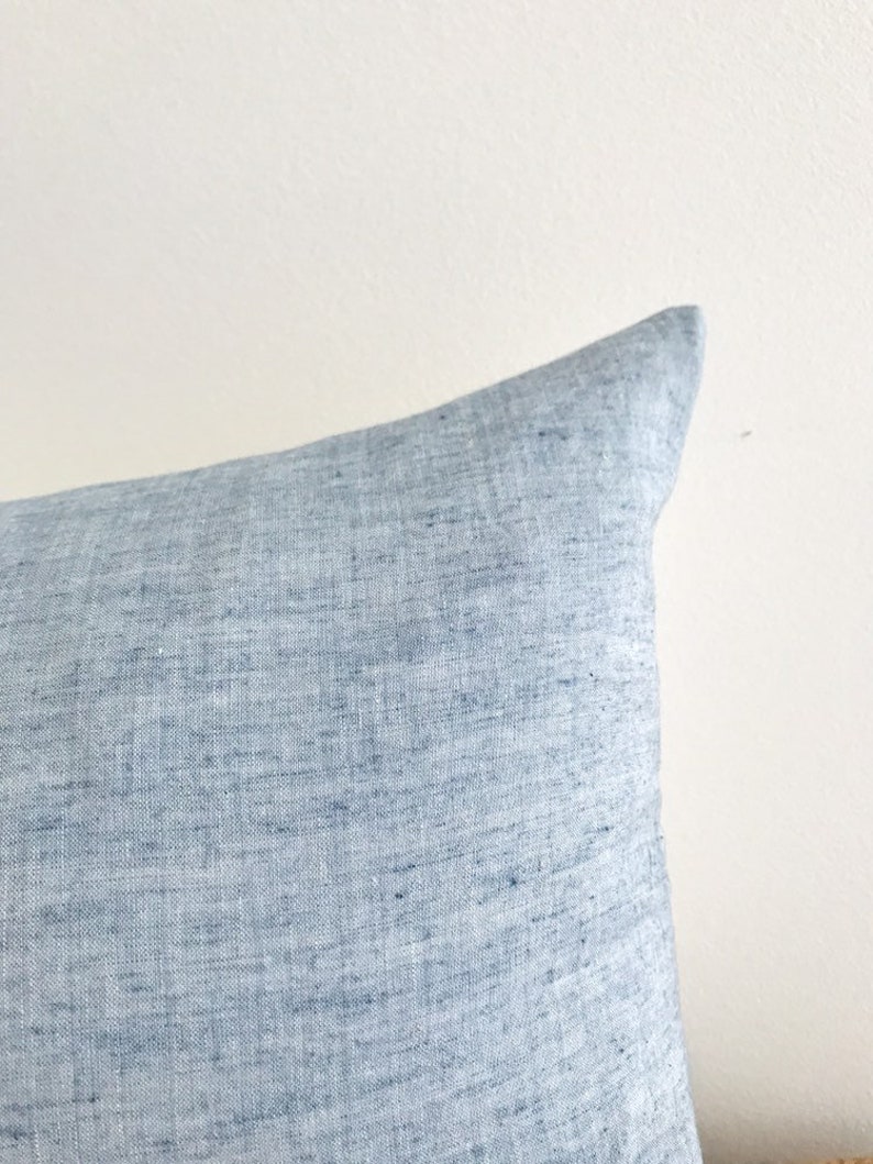 May include: A light blue linen pillow cover with a subtle textured pattern.
