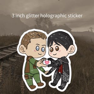 Puede incluir: Una pegatina holográfica con purpurina de 7,6 cm que muestra dos figuras de dibujos animados formando un corazón con sus manos. Una figura viste de verde y marrón, la otra de negro y gris. Texto: "3 inch glitter holographic sticker".