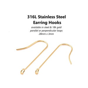 May include: Two gold-coloured earring hooks made of 316L stainless steel. The hooks are 2.8cm long and 3mm wide, with a loop at the bottom. Text on the image reads: "316L Stainless Steel Earring Hooks" and "available in steel & 18k gold parallel or perpendicular loops 28mm x 3mm".