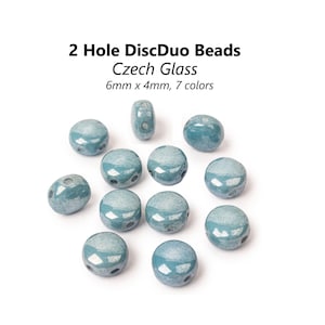 Può includere: Un gruppo di 12 perline di vetro blu chiaro con due fori ciascuna. Le perline misurano 6 mm x 4 mm e sono in vetro ceco.