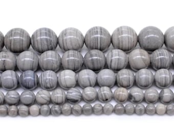 May include: A strand of gray and white striped round beads. The beads are arranged in rows of different sizes, with the largest beads at the top and the smallest beads at the bottom.