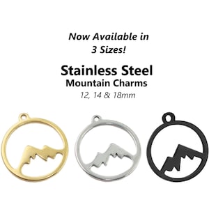 May include: Three stainless steel mountain charm pendants in gold, silver, and black. The charms are round and feature a mountain silhouette. They are available in three sizes: 12mm, 14mm, and 18mm.