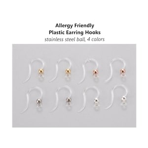 Peut inclure: Huit crochets d'oreille en plastique transparent avec une boule en acier inoxydable à l'extrémité. Les boules sont de quatre couleurs : or, or rose, argent et gris anthracite.