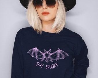 May include: A navy blue sweatshirt with a pink bat graphic and the text "Stay Spooky".