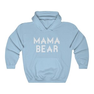 May include: A light blue hooded sweatshirt with the text "MAMA BEAR" printed in white on the front.