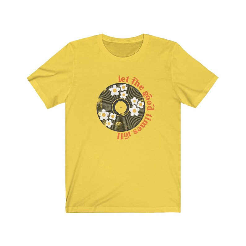 K&ouml;nnte beinhalten: Gelbes T-Shirt mit einem Vintage-Schallplatten-Design und dem Text "Let the good times roll" in Orange und Rot.