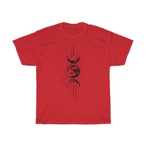 May include: A red t-shirt featuring a black graphic of the phases of the moon. The design includes crescent moons, a full moon, and dotted lines, creating a celestial theme. The shirt is made of a soft material.