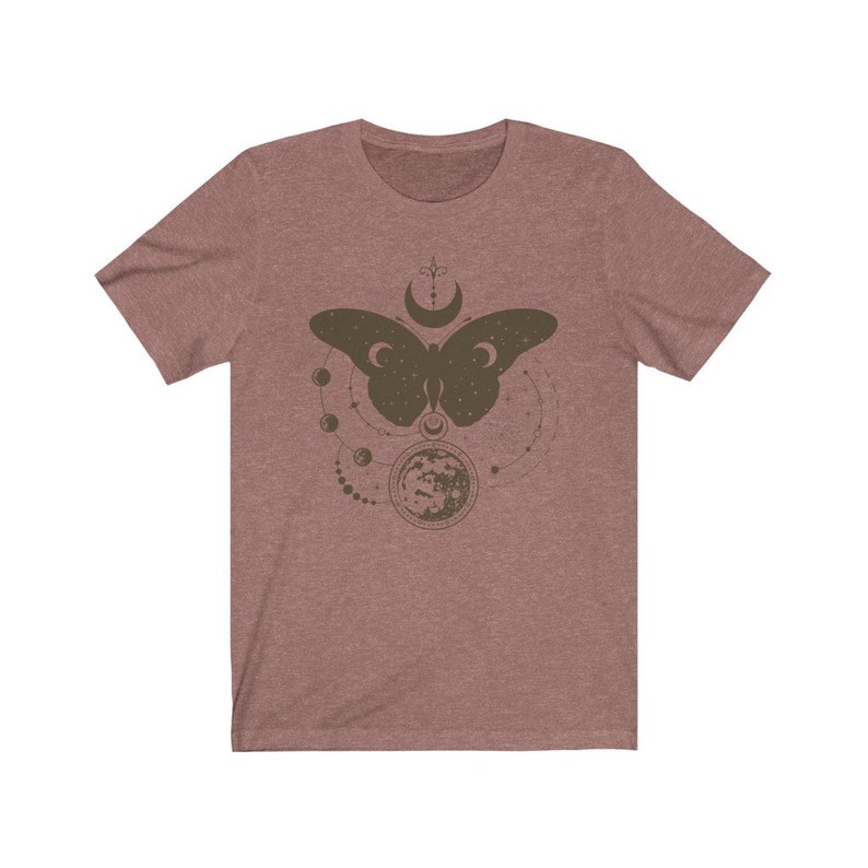 May include: A heather gray t-shirt with a brown butterfly design. The butterfly is surrounded by a circle of moons and stars.