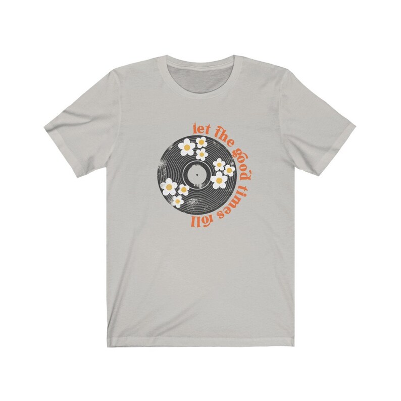 K&ouml;nnte beinhalten: Ein hellgraues T-Shirt mit einem Vintage-Schallplatten-Design. Die Schallplatte hat ein Schwarz-Wei&szlig;-Design mit wei&szlig;en G&auml;nsebl&uuml;mchen am Rand. Der Text "let the good times roll" ist in Orange um die Schallplatte herum geschrieben.