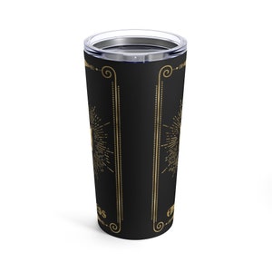 May include: A black stainless steel tumbler with a gold design. The design features a sunburst pattern and the words "Embrace the Mess" in a gold script font.