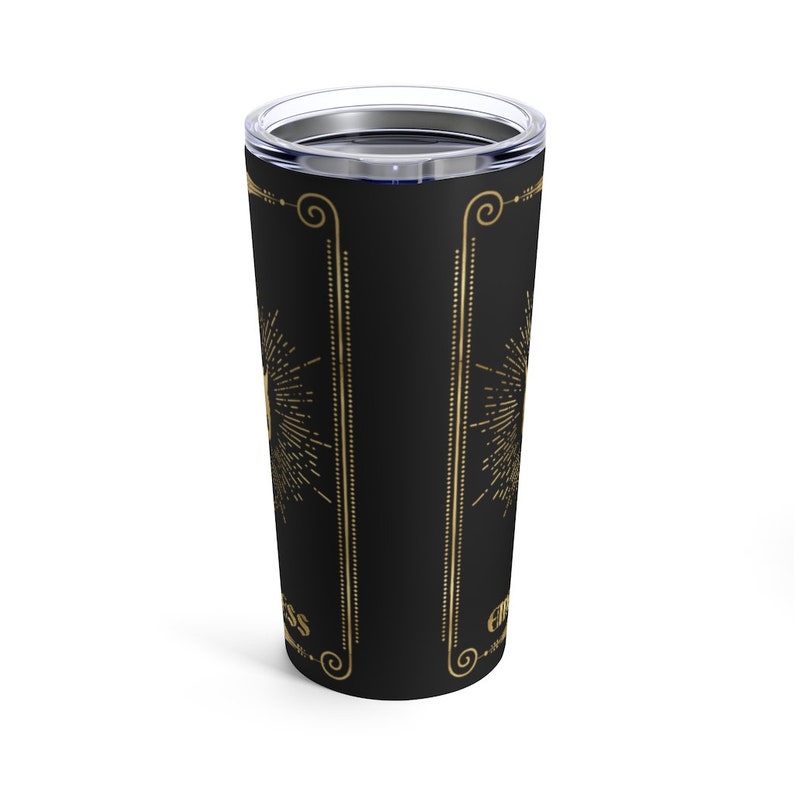 May include: A black stainless steel tumbler with a gold design. The design features a sunburst pattern and the words "Embrace the Mess" in a gold script font.