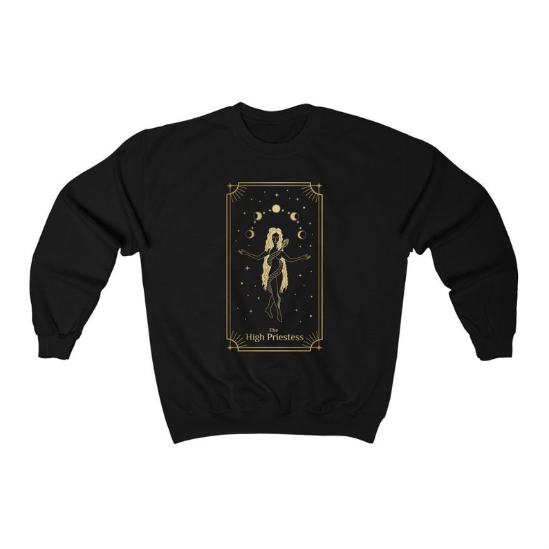 Op de afbeelding: Zwart sweatshirt met een gouden ontwerp van de Hogepriesteres tarotkaart. De kaart toont een vrouw die met haar armen gespreid staat, omringd door manen en sterren.