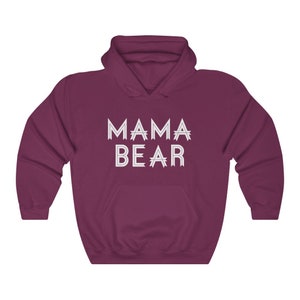 May include: A maroon hooded sweatshirt with the text "MAMA BEAR" in white outlined letters.