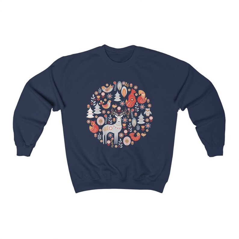 May include: Navy blue sweatshirt with a circular design featuring a deer, birds, and flowers in red, white, and blue.
