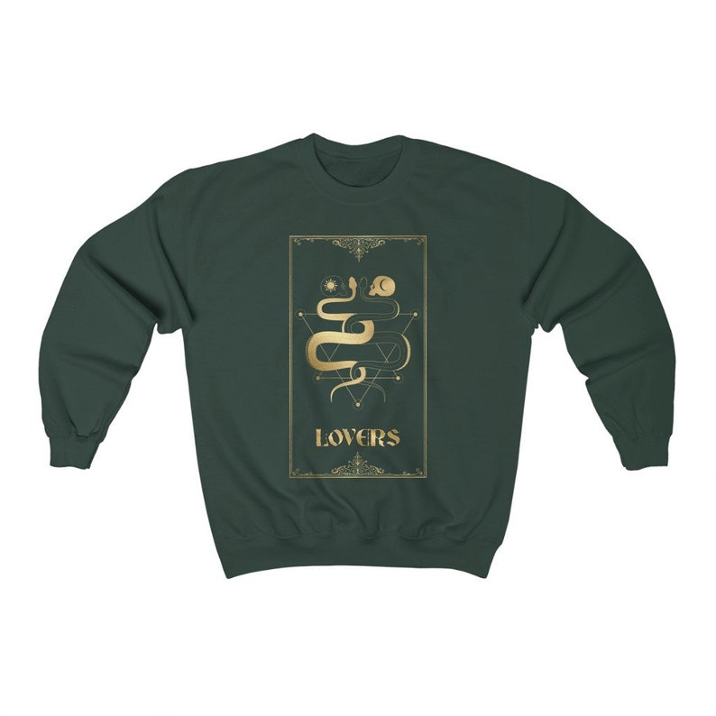 Puede incluir: Una sudadera de color verde oscuro con un dise&ntilde;o dorado de una serpiente y la palabra "LOVERS" en la parte delantera.