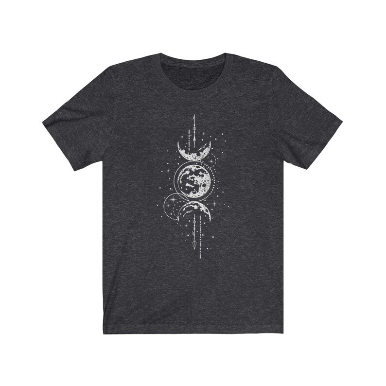 May include: A dark heather grey t-shirt with a white moon phases design. The design features three crescent moons and a full moon with stars and a line of small circles.