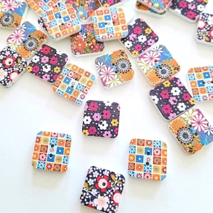 May include: Assortment of colorful square buttons with floral and geometric patterns. The buttons are made of wood and have two holes.