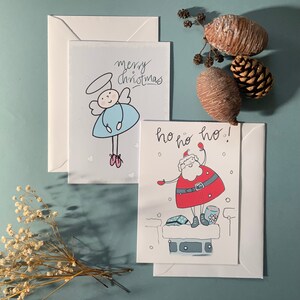 手作りクリスマスカード – サンタと天使 | かわいいクリスマスカード | 6枚パックまたは個別 | ホリデーグリーティングカード | 中小企業向け