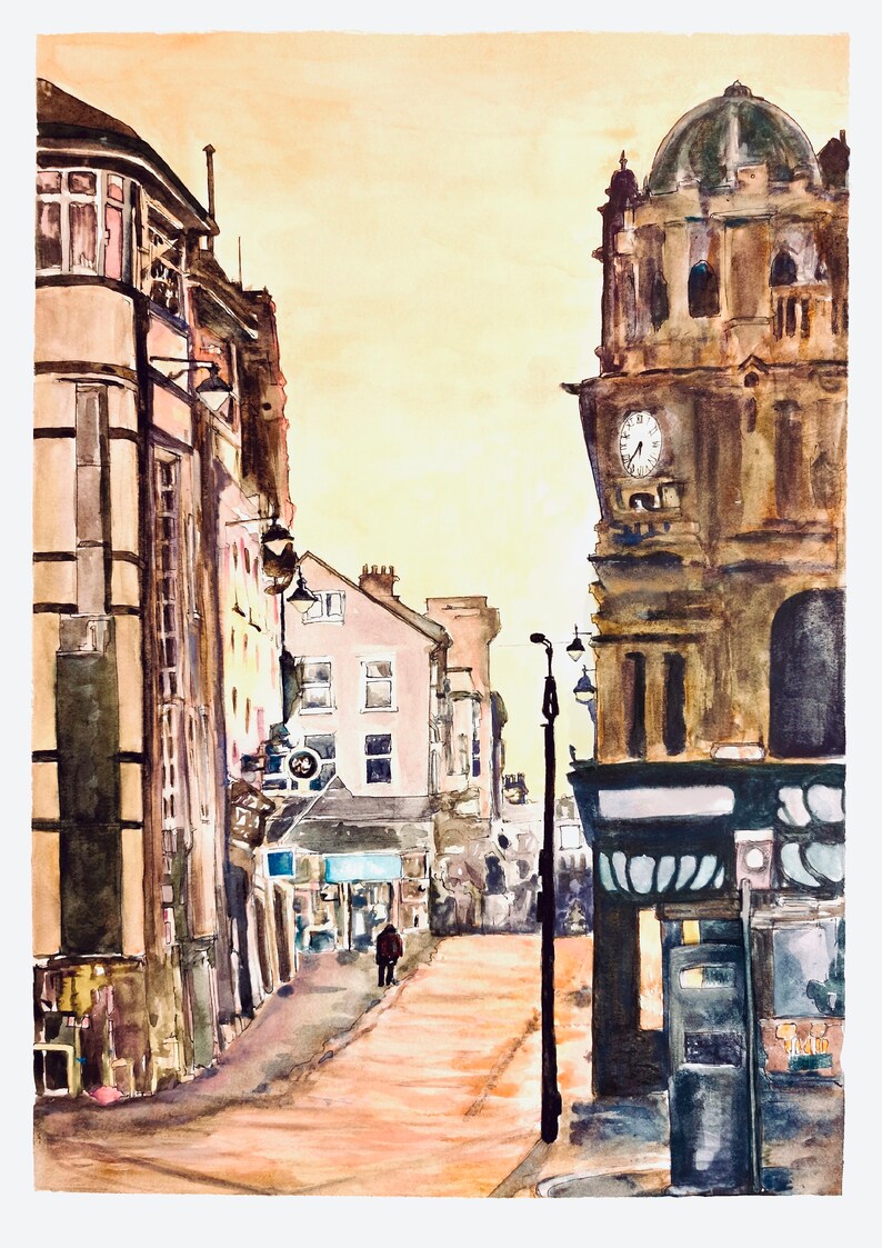 May include: A watercolor painting of a street scene in a city. The buildings are painted in shades of brown and gray, and the street is paved with cobblestones. There is a clock tower on the right side of the image, and a single person walking down the street.