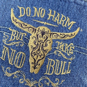 May include: Embroidered denim patch with a gold bull's head and the text "Do No Harm But Take No Bull".