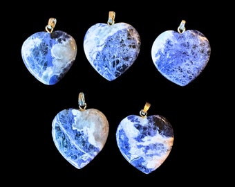 Puede incluir: Cinco colgantes en forma de corazón de sodalita azul y blanca, cada uno con una anilla de plata.