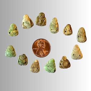 May include: A collection of 12 small, green and white ceramic figurines. The figurines are shaped like people and have a variety of poses. They are arranged in a circle around a penny.