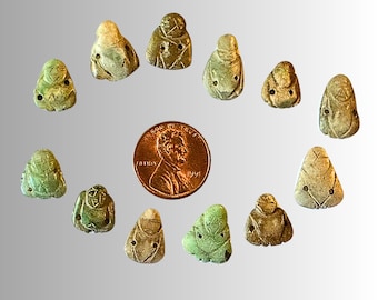 Puede incluir: Una colección de 12 pequeñas figuritas de cerámica verde y blanca. Las figuritas tienen forma de personas y tienen una variedad de poses. Están dispuestas en un círculo alrededor de un centavo.