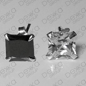 May include: Two square-cut stud earrings. One is a dark, opaque colour, and the other is clear and faceted, reflecting light. Both are set in silver-coloured metal with a post backing. The background is a light grey surface with the word "Dezka Group" repeated.