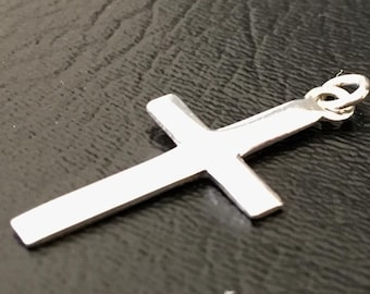 May include: A silver cross pendant with a simple design. The pendant has a loop at the top for attaching to a chain.