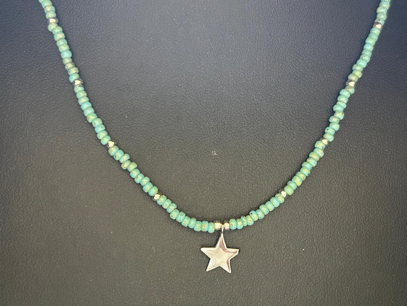 May include: A turquoise beaded necklace with a silver star charm.