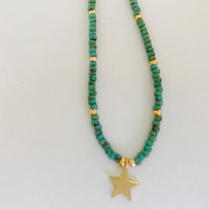 May include: A turquoise and gold beaded necklace with a gold star charm.
