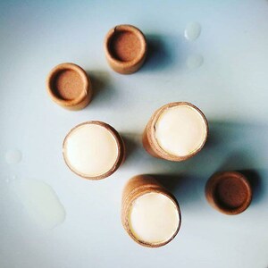 Puede incluir: Cinco tubos de cart&oacute;n marr&oacute;n con crema blanca en su interior. Cuatro de los tubos est&aacute;n tumbados y uno est&aacute; de pie. Todos los tubos son del mismo tama&ntilde;o y forma.