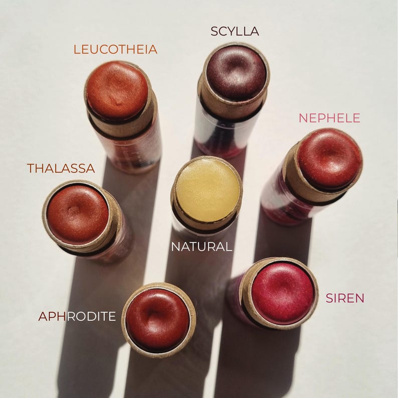Puede incluir: Siete b&aacute;lsamos labiales diferentes en una variedad de colores, incluyendo rojo, marr&oacute;n y amarillo. Los b&aacute;lsamos labiales est&aacute;n en tubos con etiquetas que incluyen los nombres: Scylla, Leucothea, Nephele, Thalassa, Natural, Aphrodite y Siren.