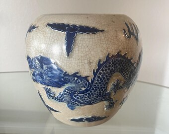 Jarrón chino antiguo con diseño de dragón y esmalte craquelado, urna de cerámica azul y blanca de estilo chinoiserie con pedestal de madera.