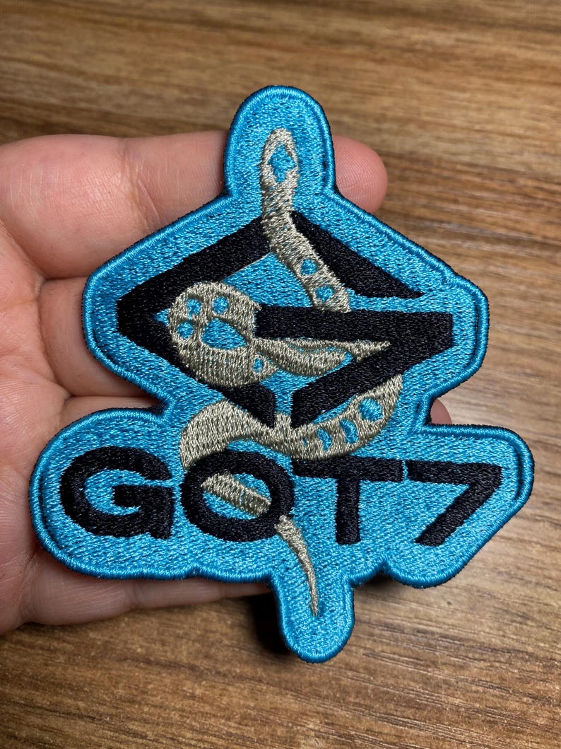 May include: A blue and black embroidered patch with a snake design and the text "GOT7".