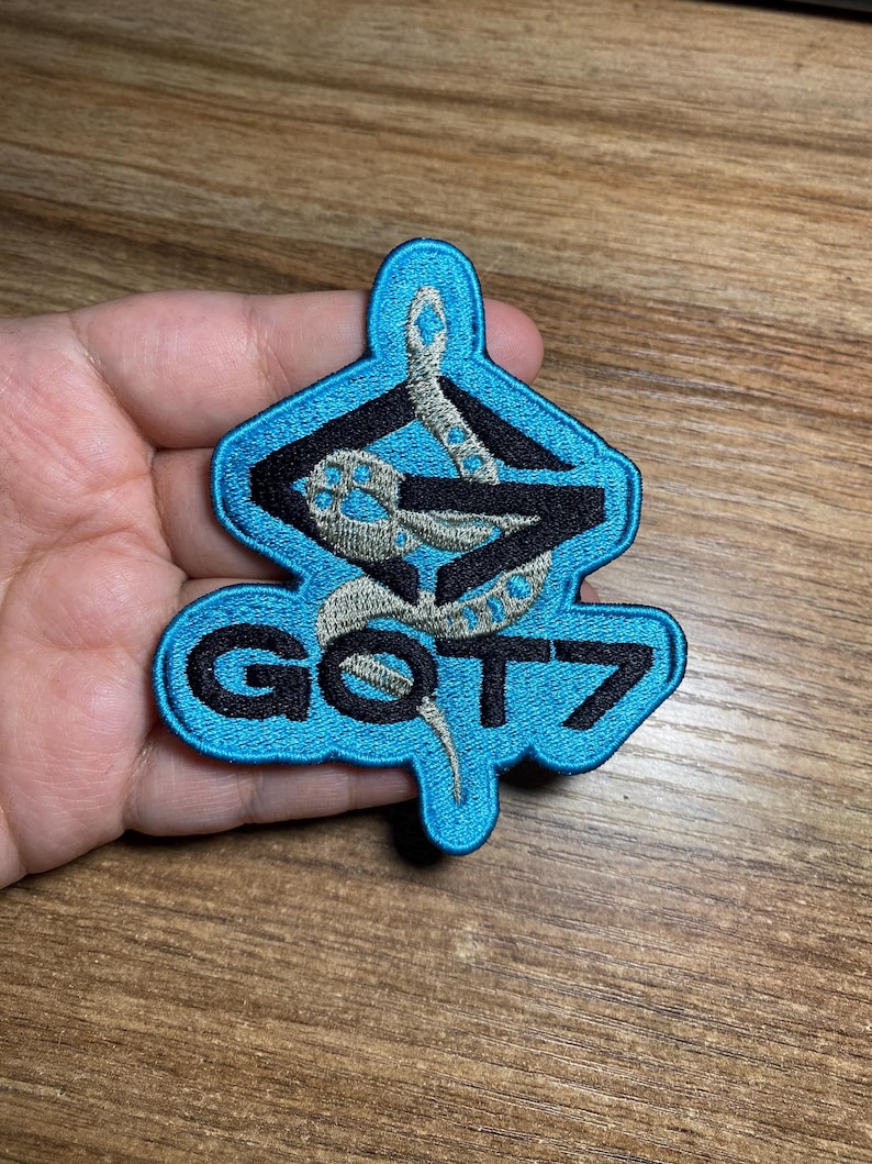 May include: A blue and black embroidered patch with a snake design and the text "GOT7".