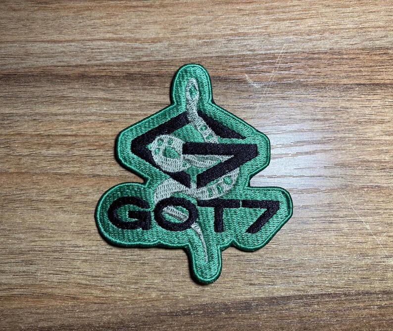 May include: Green embroidered patch with a snake design and the text "GOT7" in black.
