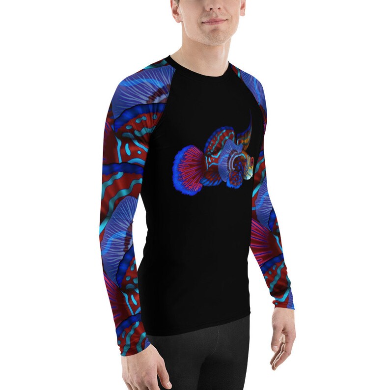 May include: A black long-sleeved shirt with a colorful fish design on the front and sleeves. The fish is red, blue, and purple with a white outline. The shirt has a crew neck and long sleeves.
