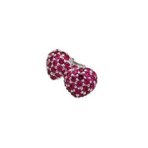 May include: A pair of silver earrings with a heart-shaped design. The hearts are covered in small, bright pink gemstones.