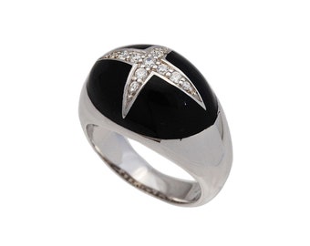 May include: A silver ring with a black enamel band and a diamond-encrusted star design.