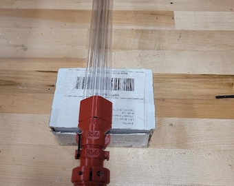May include: A red 3D-printed object with a clear tube, possibly a tool or part. The object has a cylindrical design with the numbers "356" printed on it. It is resting on a cardboard box on a wooden surface.