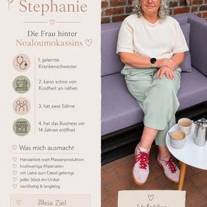 May include: A light-skinned person with curly gray hair and glasses sits on a purple sofa, wearing a cream-colored ribbed shirt and light green trousers. Beside them is a white table with two mugs and a silver coffee press on a brick patio.