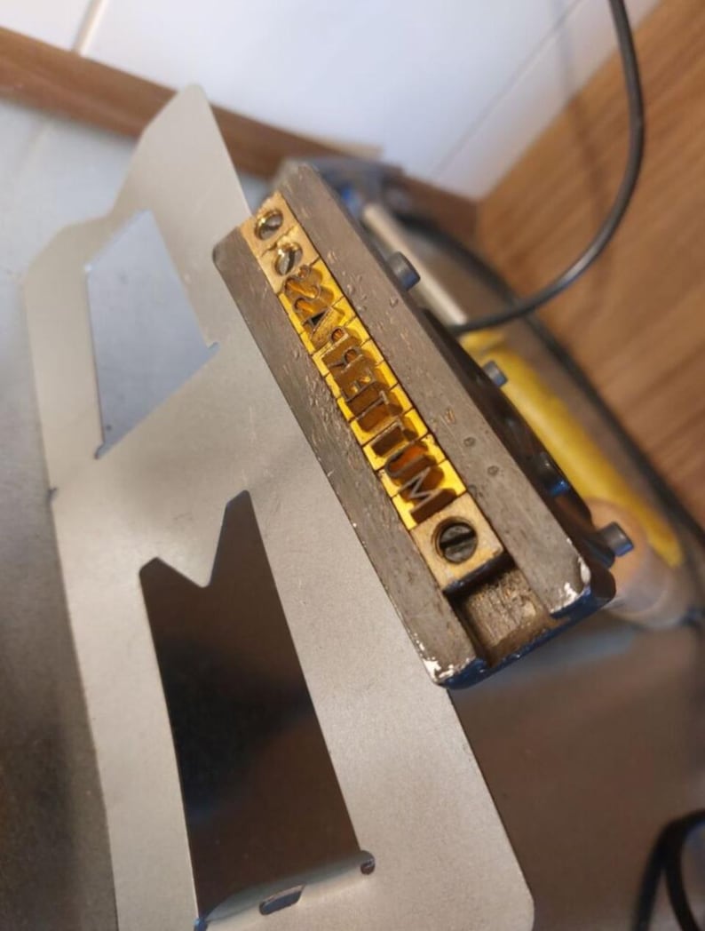 Handbrandstempel in den die Buchstaben einzeln einsortiert werden.